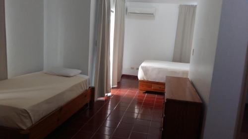 a small room with two beds and a window at Hotel Zapata in Boca Chica