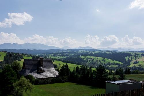 a house sitting on top of a lush green field at Miętowa Górka in Ząb