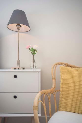 a lamp and a chair next to a dresser at The Bond Studio FREE PARKING in Zandvoort