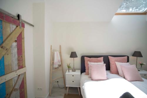 a bedroom with a bed with pink pillows on it at The Bond Studio FREE PARKING in Zandvoort