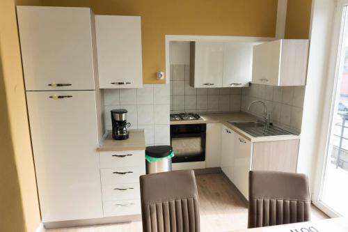 a small kitchen with white cabinets and a sink at Trendy apartmant in city in Maribor