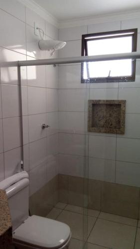 a bathroom with a shower with a toilet and a window at Vital Hotel in Marechal Floriano