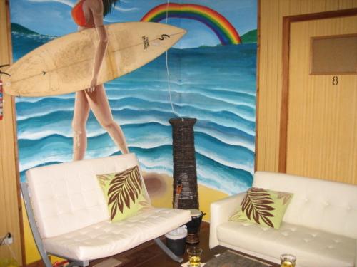 mural de un surfista sosteniendo una tabla de surf en una habitación en Emix Ishigaki, en Ishigaki Island