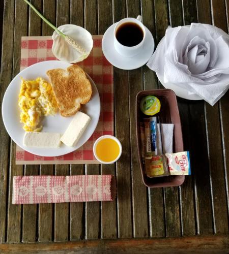 un plato de desayuno con huevos y tostadas y una taza de café en Hotel Villa Carolina, en Santa Rosa de Cabal