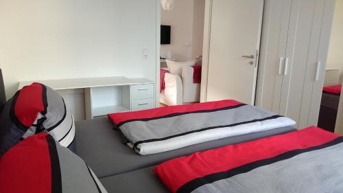 アレンスバッハにあるBodenSEE Apartment Allensbach FEWO 1のベッドルーム1室(ベッド2台、デスク、鏡付)