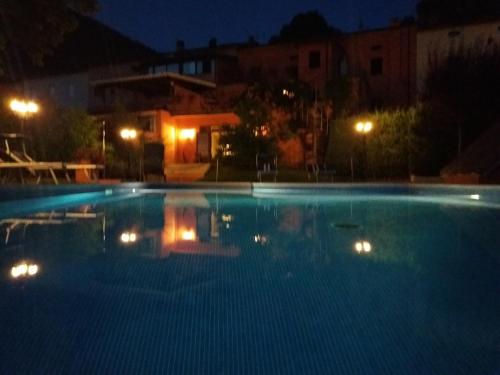 a large swimming pool at night with lights in it at Albergo Montenerone in Piobbico