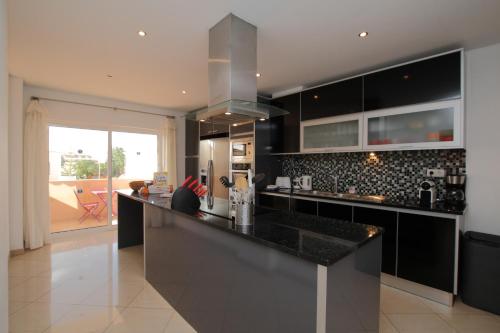 a kitchen with black cabinets and a counter top at Full private 300sqm Villa Jacuzzi Heated Pool Ideal & quiet location in Albufeira