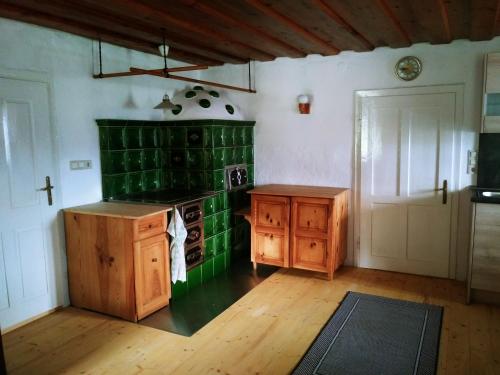 a kitchen with green tile on the wall and a stove at Ferienhaus Herrnbauer in Zaglau