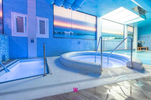 baño grande con bañera y piscina en Hotel Spa Norat O Grove 3* Superior, en O Grove