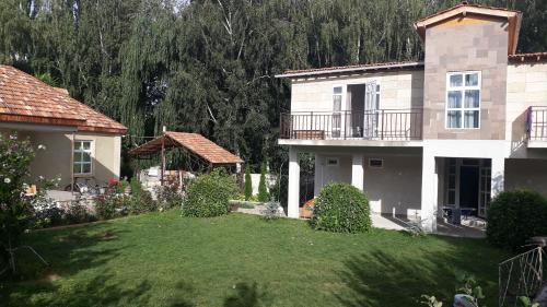 una casa grande con un patio delante en Zaton Guesthouse en Cholpon-Ata