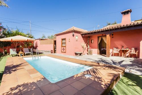 a house with a swimming pool in front of a house at El Tendal in Puntagorda