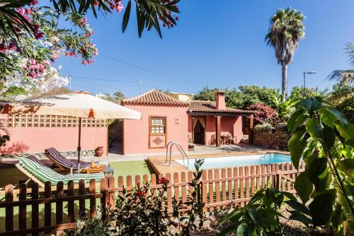 a pink house with a fence and a swimming pool at El Tendal in Puntagorda