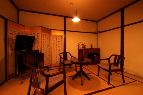a dining room with a table and chairs in a room at Park Lodge Sekine in Myoko