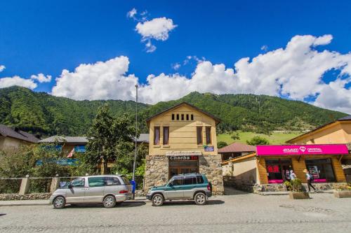 two cars parked in a parking lot in front of a building at Eka&Nino GuestHouse in Mestia