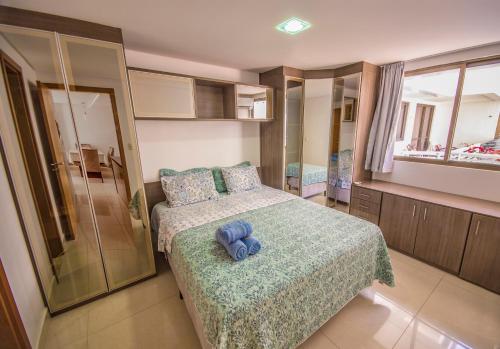 Un dormitorio con una cama con un osito de peluche azul. en Unique Beach - Pé Na Areia en João Pessoa