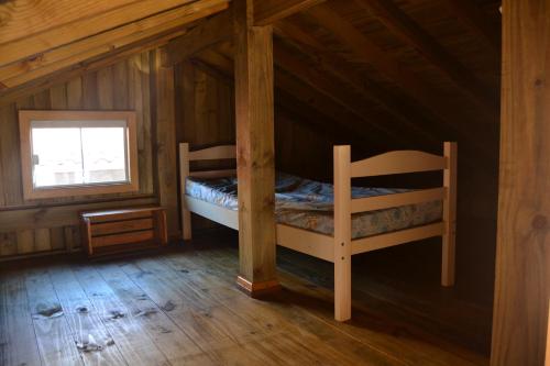 a bedroom with a bunk bed in a cabin at Paraiso na Garopaba do Sul ( Farol de Santa Marta) in Jaguaruna