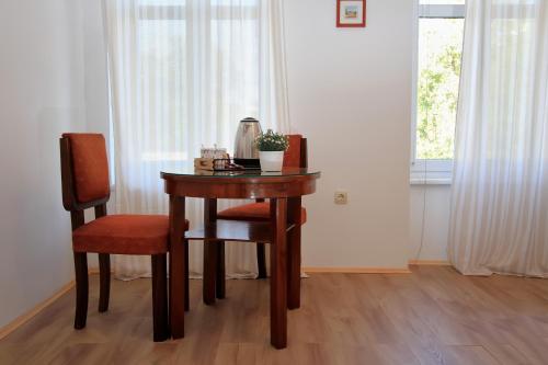 a wooden table with two chairs and a table with a lamp at Bivium in Otočac