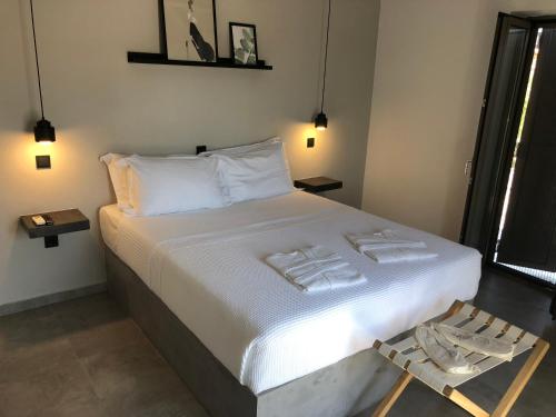 a bedroom with a large bed with white sheets at Calme Suites Mani in Agios Nikolaos