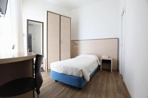 a small bedroom with a bed and a desk at Hotel Daniel's FRONTE MARE in Riccione
