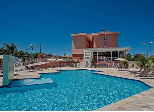 a swimming pool in front of a building at The Hill Hotéis Executive in São Carlos