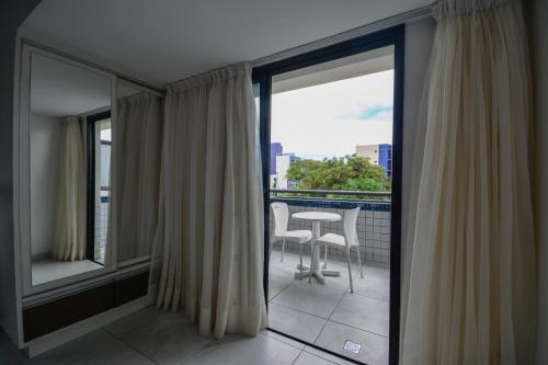 a balcony with a view of a table and chairs at Littoral Tambaú Flat in João Pessoa