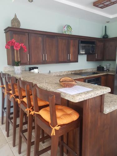 a kitchen with a large island with wooden cabinets at Casa Malia Guapinol #8 in Tamarindo