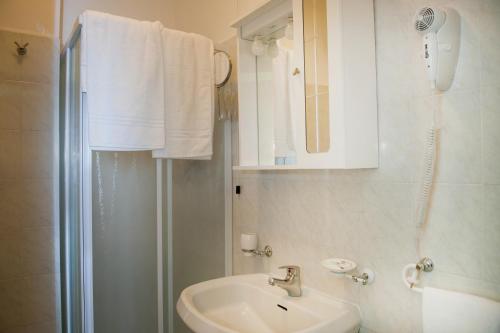 y baño blanco con lavabo y ducha. en Hotel Centrale di Paolo e Cinzia, en Loreto