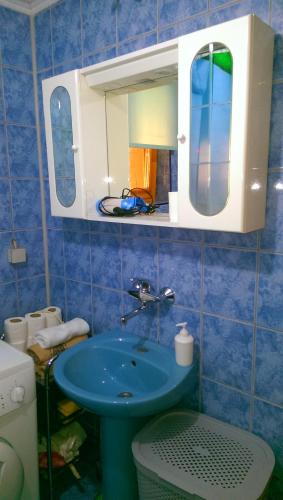 a blue bathroom with a sink and a mirror at Holiday House Afan in Hadžići