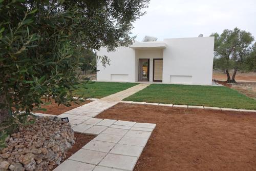 a white house with a walkway in front of it at giardino del tempo in Merine