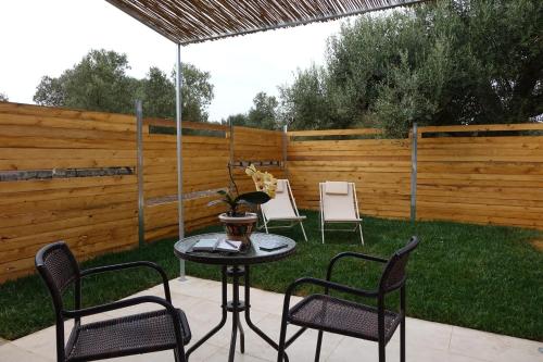 a patio with chairs and a table with an umbrella at giardino del tempo in Merine