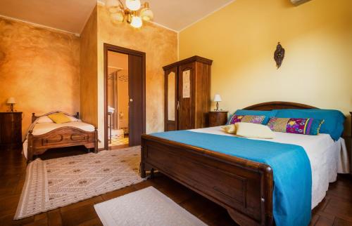 - une chambre avec un grand lit et une couverture bleue dans l'établissement Su Connotu, à Sestu