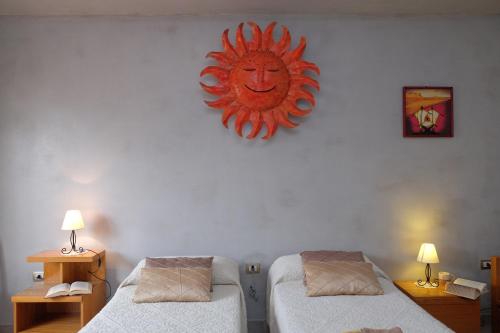a room with two beds and a sun sign on the wall at Su Connotu in Sestu