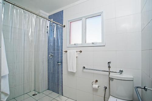 a bathroom with a shower and a toilet and a window at The Hill Hotéis Executive in São Carlos