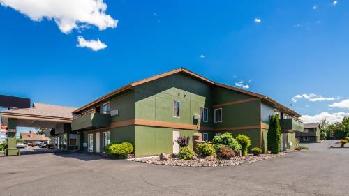 um grande edifício verde num parque de estacionamento em RiverTree Inn & Suites em Clarkston