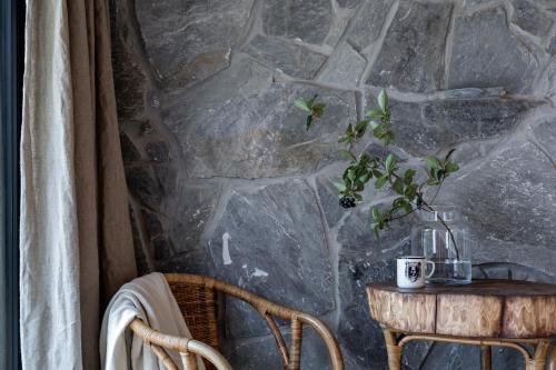 a table with a vase on it next to a stone wall at Miętowa Górka in Ząb
