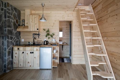 a kitchen with a staircase in a log cabin at Miętowa Górka in Ząb