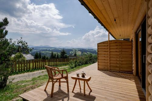 a wooden deck with a chair and a table at Miętowa Górka in Ząb