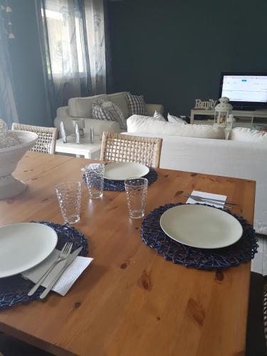 a wooden table with plates and utensils on it at Cadaques Caribe Pez 103 in Bayahibe
