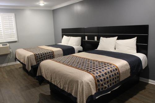two beds in a hotel room with two beds at ERTH INN by AGA Los Angeles in Los Angeles
