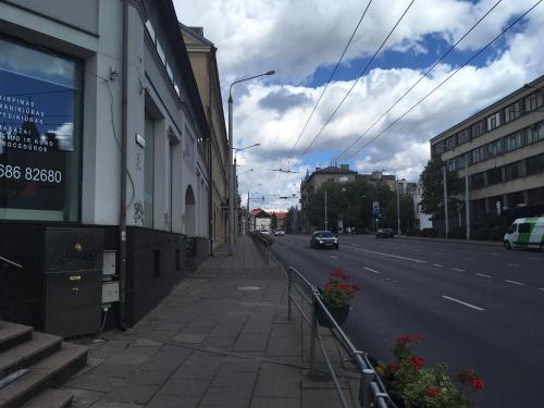 een lege stadsstraat met een auto geparkeerd op de weg bij Emi apartment in Vilnius