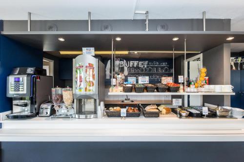 a bakery with a counter with food on it at Ibis Budget Montelimar in Montélimar