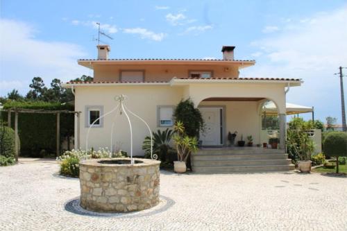 a house with a fountain in front of it at Casa do Riacho in Esposende