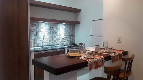 a kitchen with a wooden table and a stove top oven at Villa Água de Coco in Jericoacoara