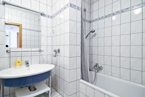 a white bathroom with a sink and a shower at Top Apartmentwohnungen Veltins Arena in Gelsenkirchen