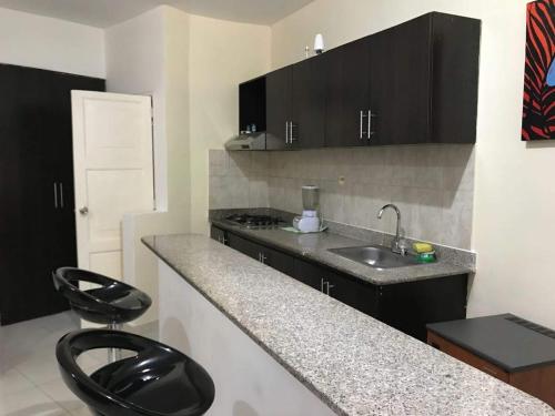 a kitchen with a sink and a counter top at Arco Apartasuites in Cali