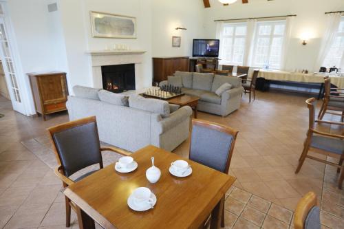 a living room with a couch and a table and chairs at Leśniczówka Nibork in Nidzica