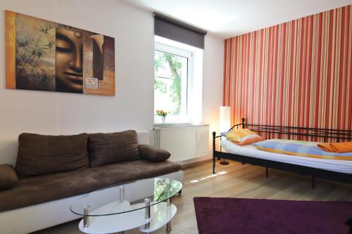 a living room with a couch and a bed at Top Apartmentwohnungen Veltins Arena in Gelsenkirchen