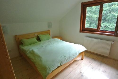 バリウグにあるChalet by the riverのベッドルーム1室(緑のシーツが敷かれたベッド1台、窓付)