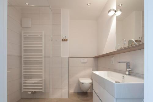 ノルダーナイにあるDeluxe Suite Kleine weiße Düne (mit West- u. Ostbalkon)の白いバスルーム(洗面台、トイレ付)