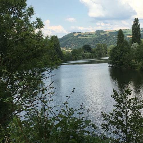 a view of a river with trees and hills at Gîte:"sur le chemin" in Livinhac-le-Haut